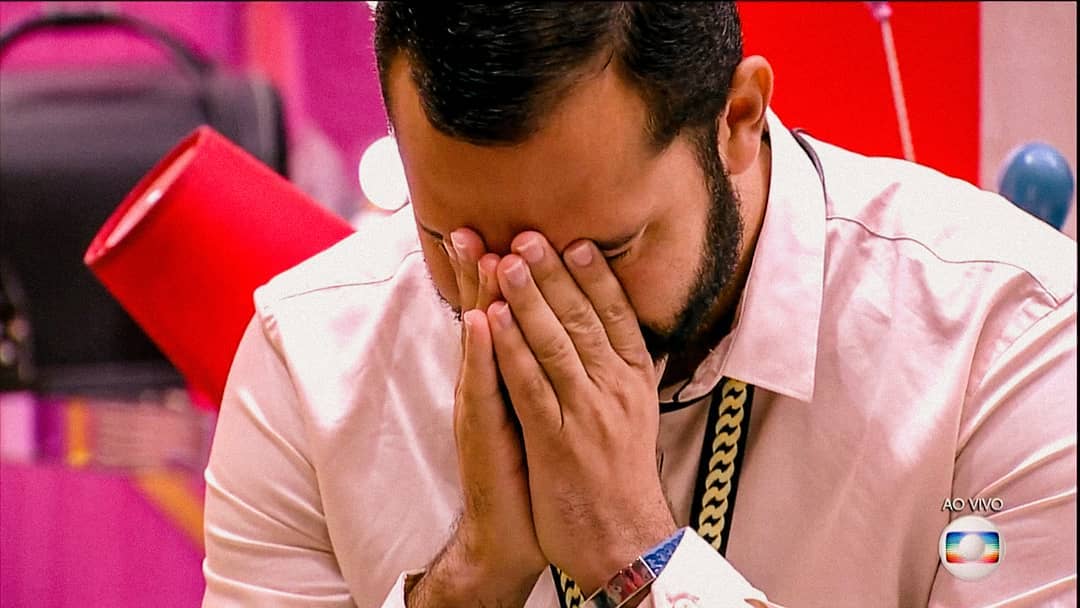 Gilberto aparece com as duas mãos no rosto, com a expressão de preocupação.