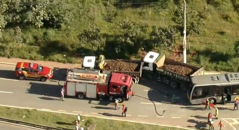 A imagem mostra um acidente entre um ônibus e um caminhão, além de viatura da polícia no meio da rua