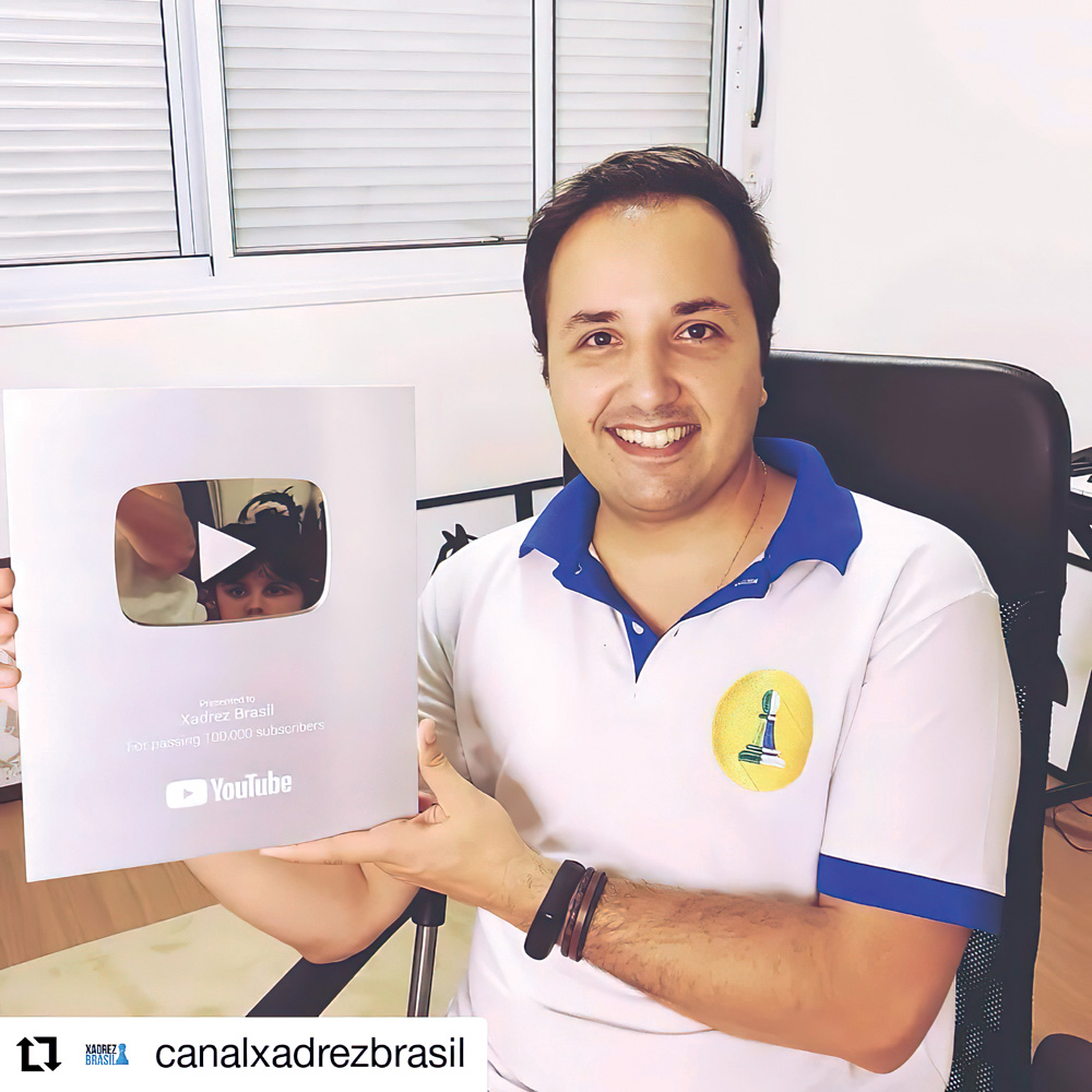 xadrez-youtuber-placa-inscritos.jpg Rafael posando para a foto segurando sua placa comemorativa de 100 mil inscritos no youtube