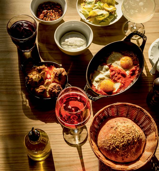 Mesa cheia de itens disponíveis no brunch da pizzaria Carlos.
