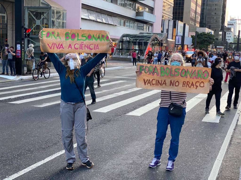 manifestação avenida paulista Imagem mostra duas mulheres com máscara segurando cartazes que dizem: