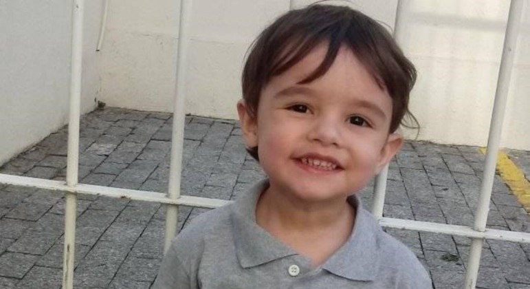 A imagem mostra o menino Gael, de três anos, posando para a câmera e sorrindo