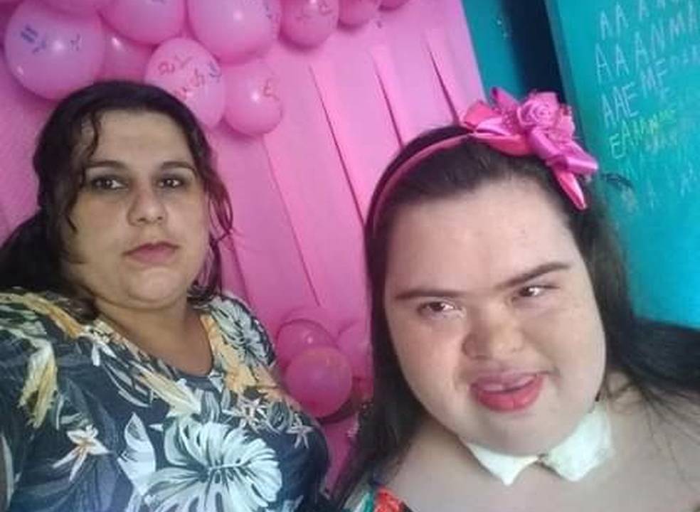 A imagem mostra Amanda, sorrindo, com sua mãe em uma selfie.