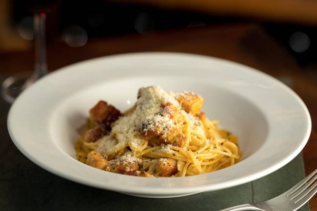 Antonietta Cucina – Carbonara di Pato – Henrique Peron (4) Carbonara de pato coberto por queijo em prato fundo de louça branca.