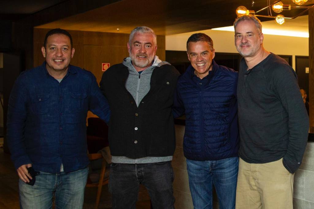 Teco Medina, Alex Atala, Caio Mesquita e Dan Stulbach (Divulgação-Empiricus) A partir da esquerda, Teco Medina, Alex Atala, Caio Mesquita e Dan Stulbach posam abraçados olhando para a câmera em um ambiente fechado.