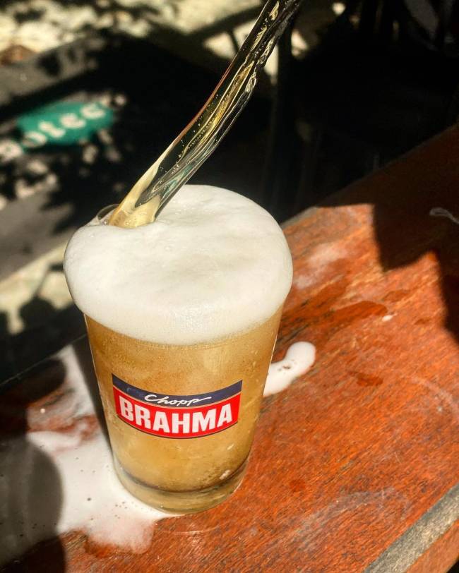 Boteco Belmonte Foto de chope Brahma sendo tirado sobre mesa de madeira.