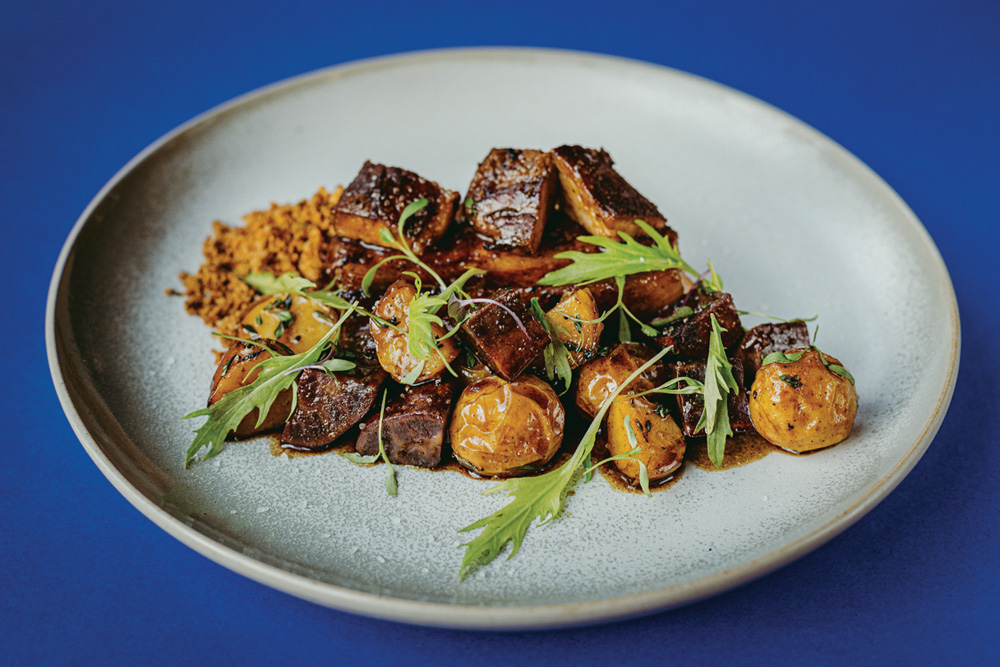 Dia dos Pais – Animus Prato de cerâmica sobre superfície azul com costelinha de porco picada junto de batatas assadas e à farofa.