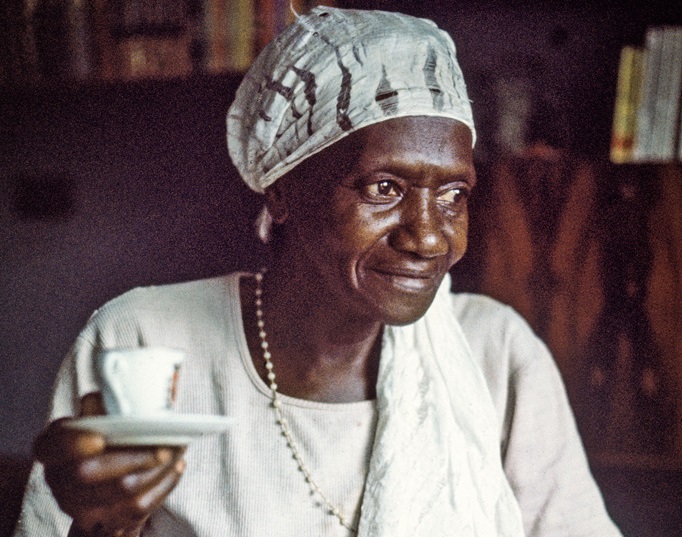 Carolina Maria de Jesus, autora do livro "Quarto de Despejo", tomando café com um lenço amarrado na cabeça.