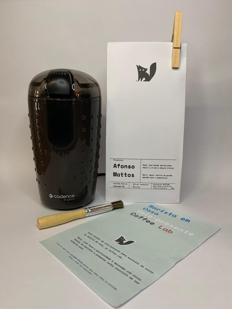 Dia dos Pais – Coffee Lab Kit com uma embalagem branca de café do lado direito, moedor de café e pincel e papel à frente.