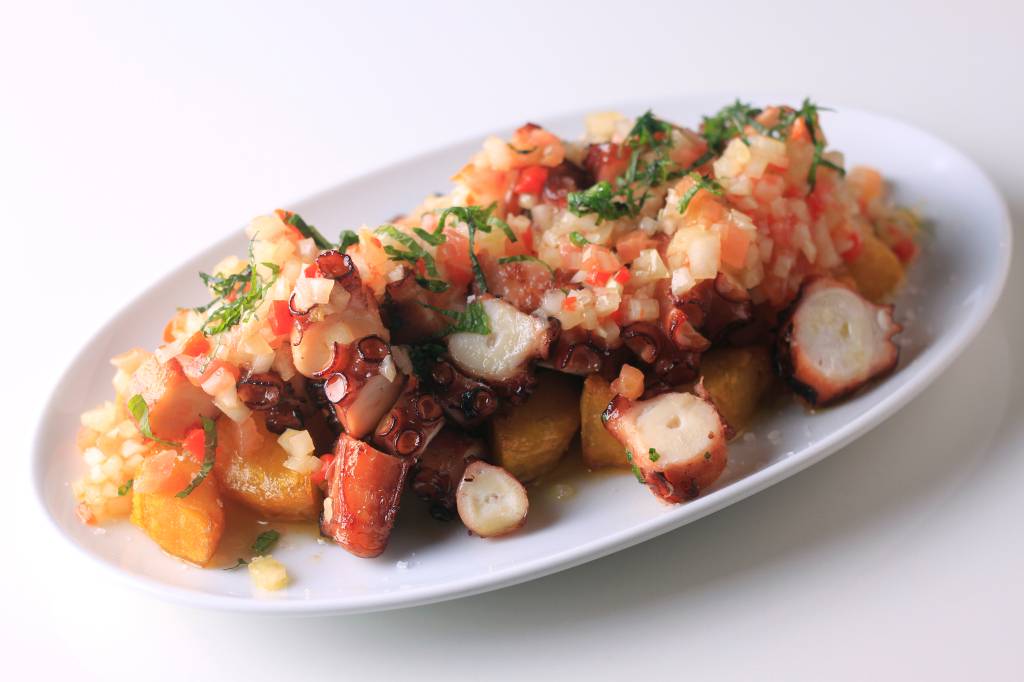 Vinagrete de Polvo – Tasca da Esquina Travessa oval de louça branca com vinagrete de polvo.