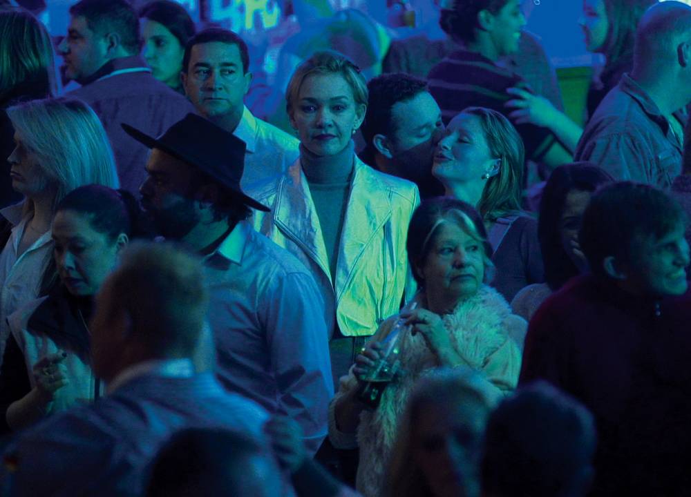A imagem mostra Julia em uma rua completamente lotada de pessoas em cena do filme.