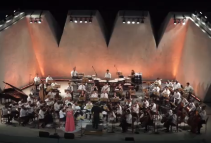 Foto aérea de orquestra posicionada em palco.