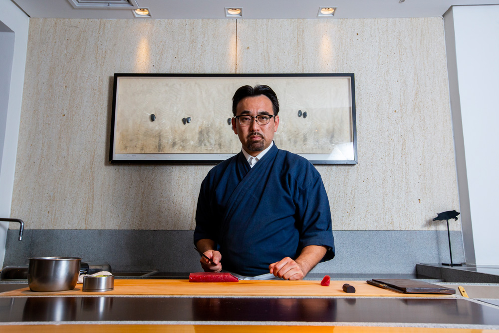 Jun Sakamoto fatiando peixe no balcão de seu restaurante em Pinheiros.