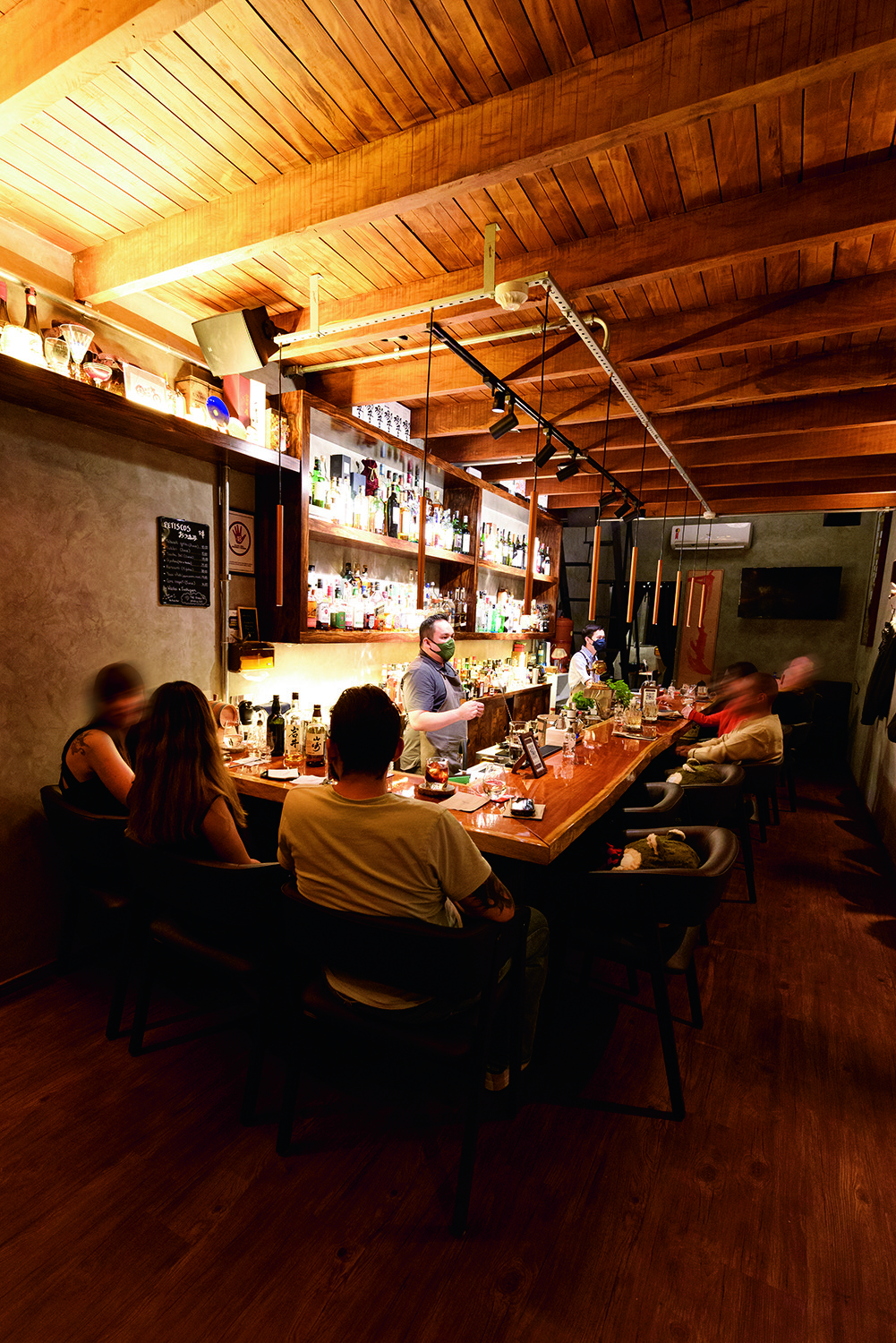 The Punch Bar Balcão do The Punch Bar à esquerda com clientes sentados em banquetas.