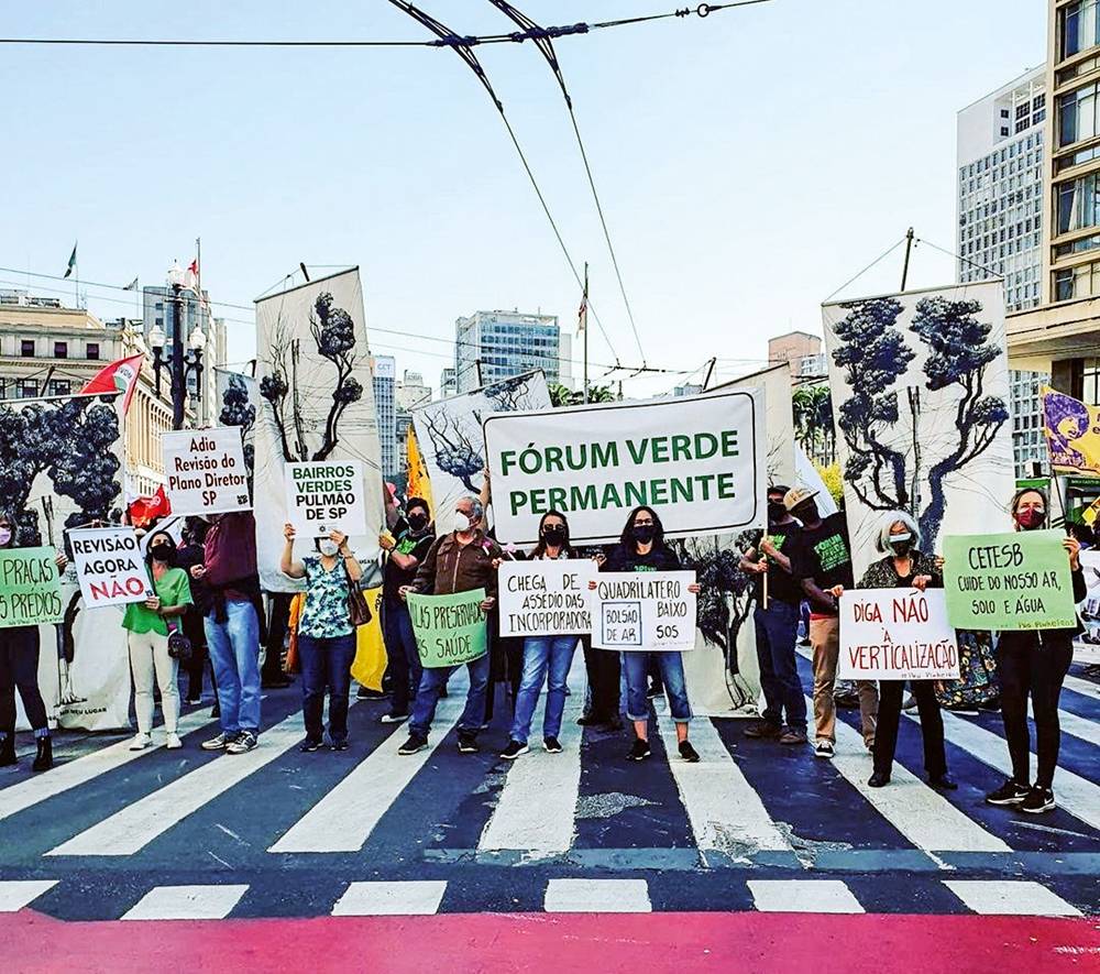 protesto-entidade-pró-pinheiros-moradores-contra-verticalização-bairro-pinheiros.jpg pessoas reunidas em rua à frente da prefeitura, no centro de São Paulo, com equipamentos de proteção contra a covid, em protesto pedindo o adiamento da revisão do plano diretor e com diversas faixas contendo reivindicações das mais diversas, como pró-quadrilátero das Vilas do Sol, pedindo fórum verde permanente e contra a verticalização da cidade
