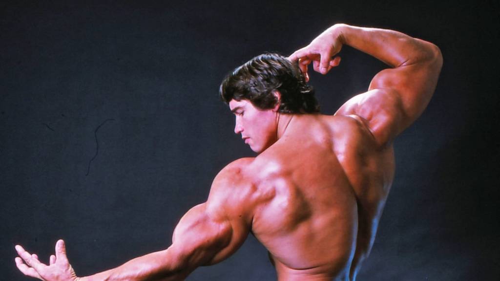arnold-schwarzenegger-posição-músculos-costas-filme-homem-dos-músculos-de-aço Arnold Schwarzenegger de costas fazendo pose com os músculos no filme