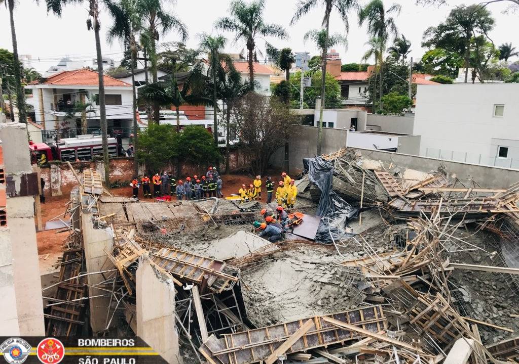 Imagem mostra bombeiros em cima de escombros tentando resgatar vítima em terreno de obras