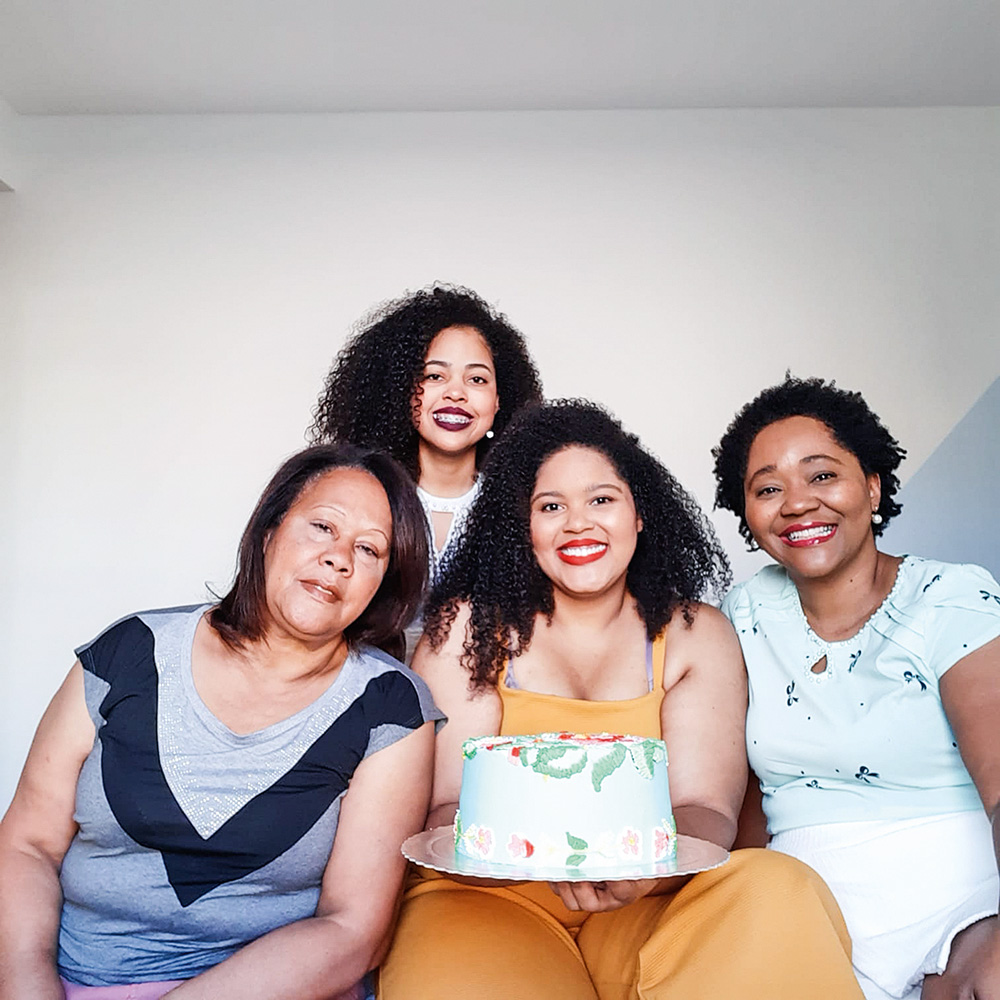 foto família – bolos da Piri Confeitaria Quatro mulheres sorriem e olham para a câmera. A do centro segura um bolo