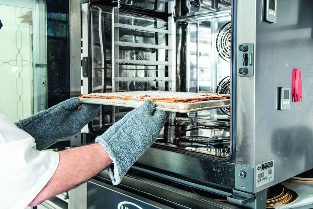 COMER & BEBER 2021 – Crime Pastry Shop Massa folhada sendo colocada em forno industrial.