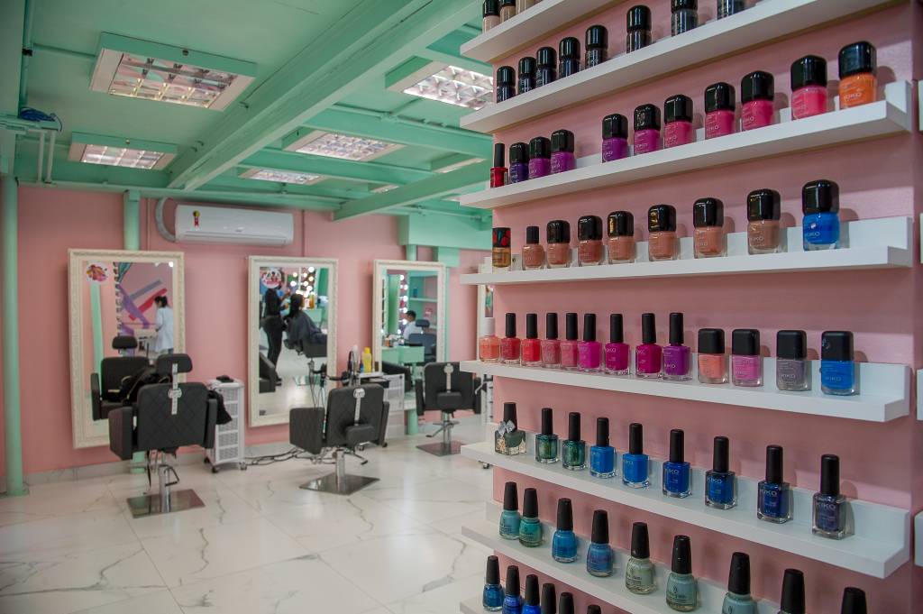 I Love Me (Rogério Pallatta-VejaSP) (8) Decoração da barbearia I Love Me exibe pilar cheio de esmaltes e cadeiras ao fundo. Paredes nas cores verde claro e rosa.