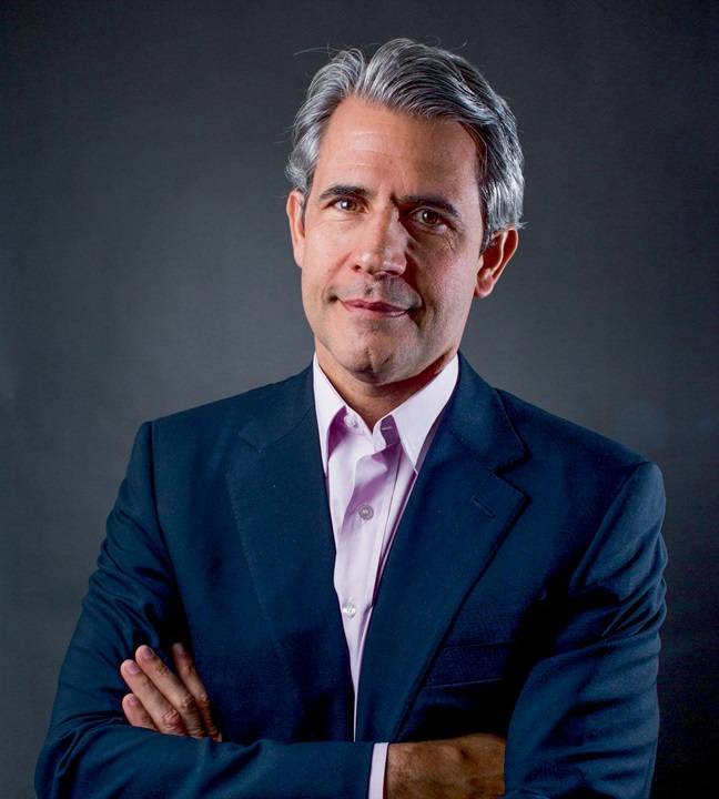 Luiz Felipe D'Avila veste terno azul marinho e posa de braços cruzados.