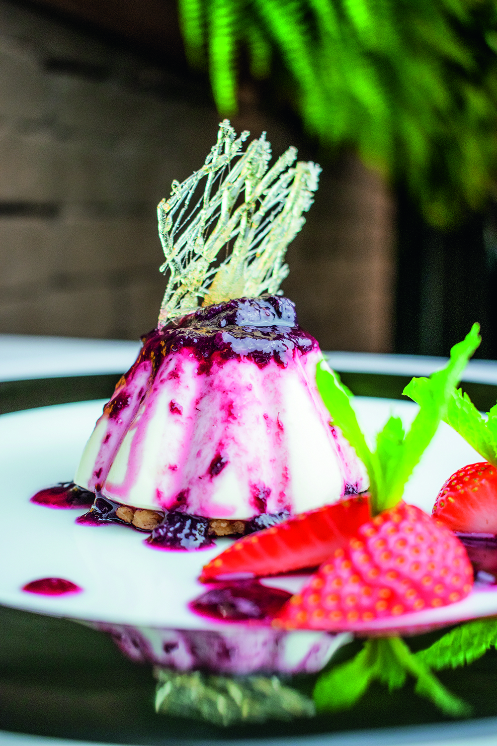 Panacota ao lado de peda&ccedil;os de morango.