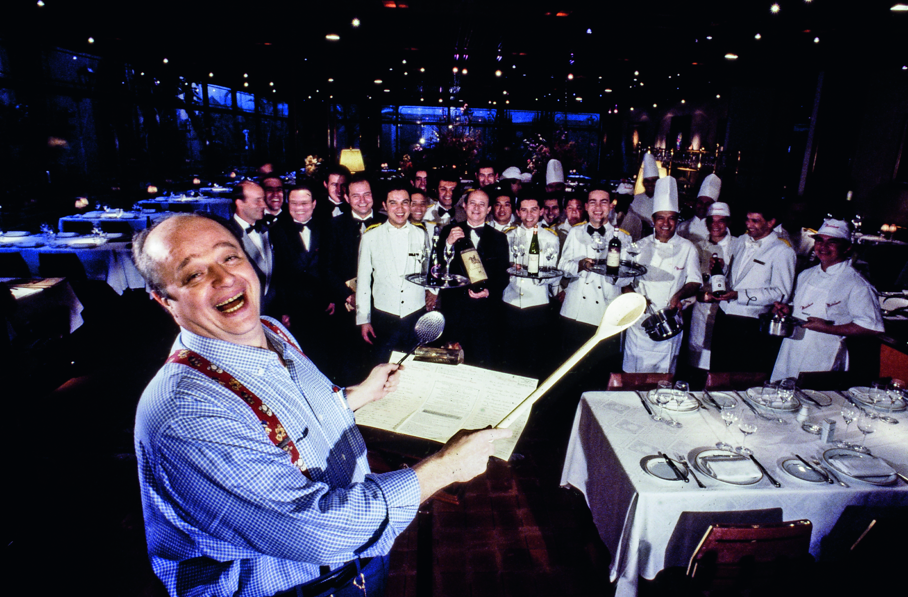 Massimo Ferrari sorrindo no canto esquerdo da foto enquanto segura uma colher de pau 