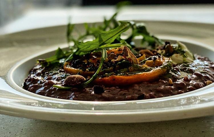Prato de risoto de azeitona decorado por folhas