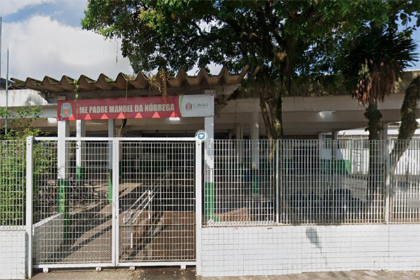 Imagem mostra fachada de escola, com portões fechados e letreiro: UME Padre Manoel da Nóbrega