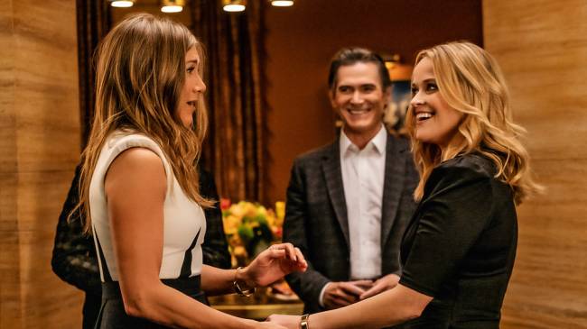 the morning show – cred divulgacao.jpg A imagem mostra Jennifer Aniston e Reese Witherspoon em cena de The Morning Show. Jennifer está com cara de surpresa enquanto aperta a mão de Reese.