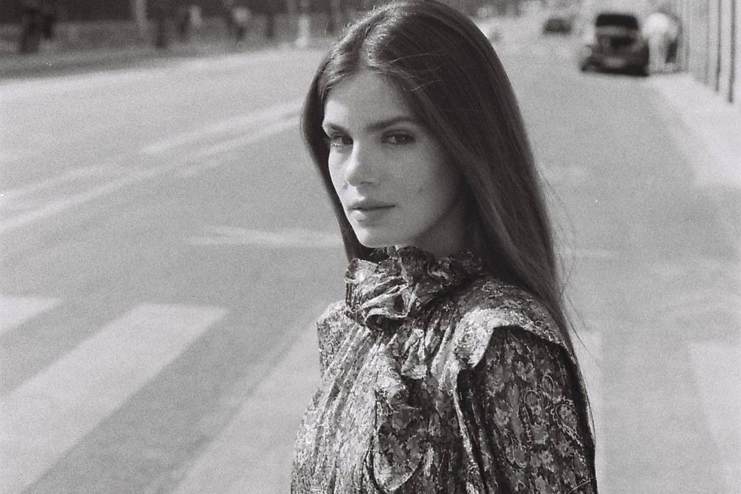 Imagem mostra Camila Queiroz séria, em foto no meio da rua, em cima de faixa de pedestres