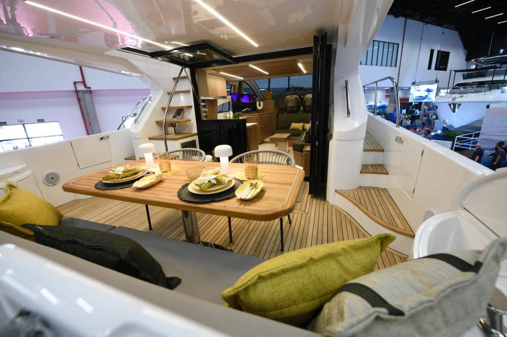 Boat Show (Alexandre Battibugli) (3) Foto exibe interior de lancha com cadeiras, escada e cozinha.