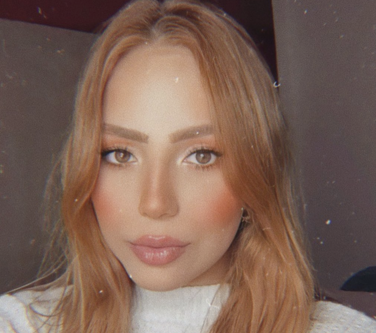 Selfie de mulher de cabelo castanho claro e bochechas rosadas