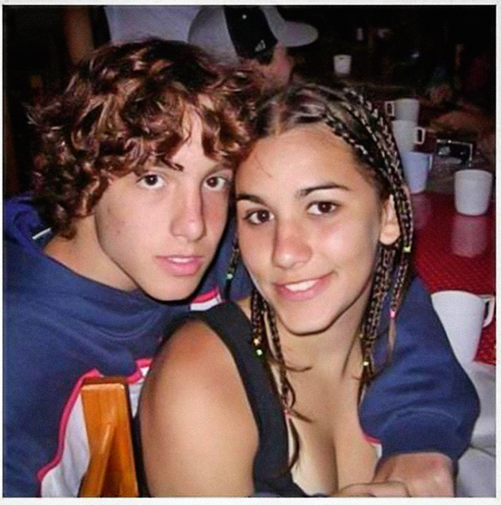 Foto 1 Camila e Eduardo.jpg A imagem mostra Mila e Russo, jovens, abraçados e sorrindo para a foto.