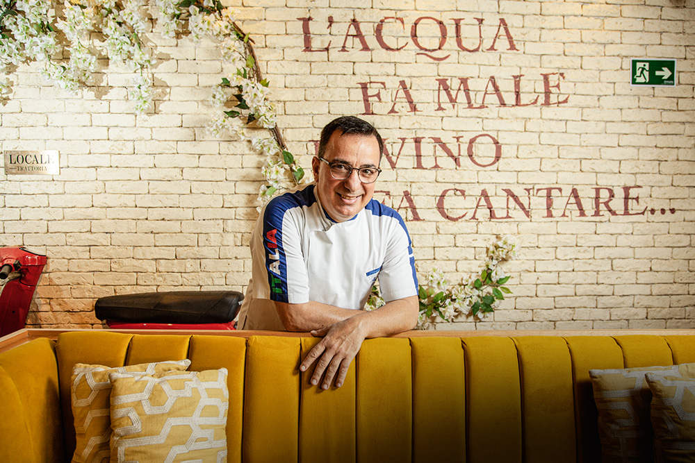 Locale Trattoria O chef Augusto Piras encostado em sofá estofado amarelo no Locale Trattoria.