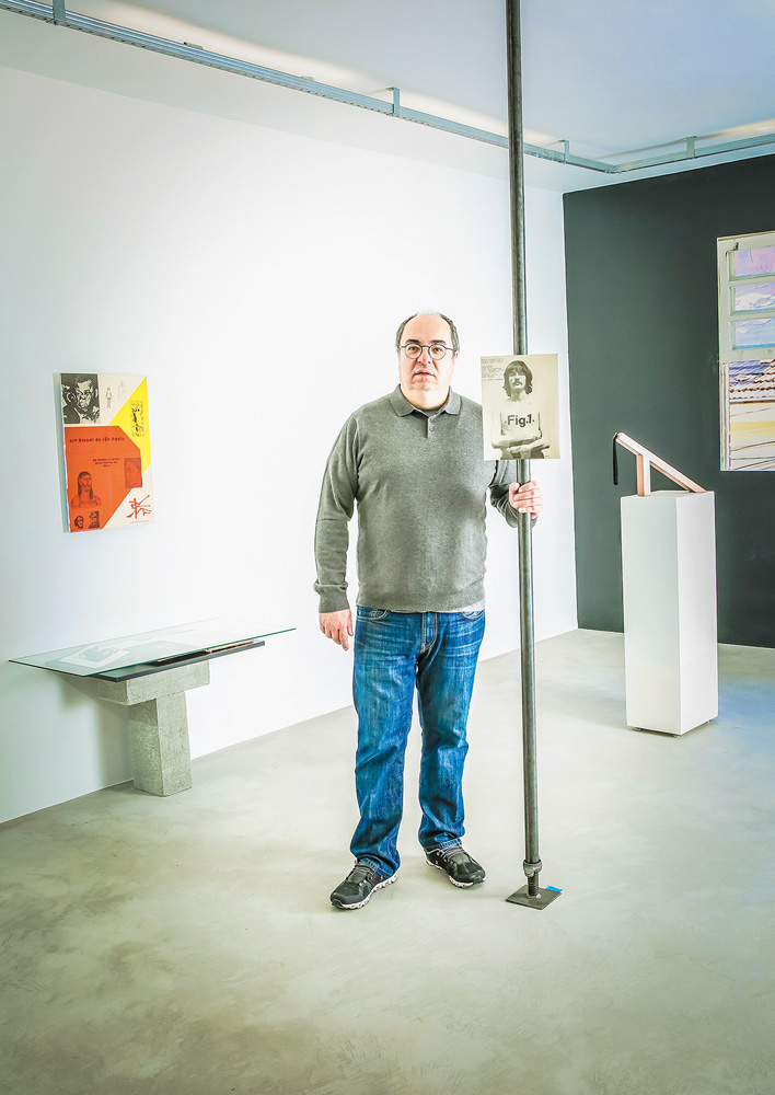 São Paulo 16 novembro 2021Travessa Dona PaulaFoto Alexandre Battibugli VSP Um homem grisalho de meia idade posa em uma galeria de arte. Ele segura um cabo que tem uma foto antiga pendurada