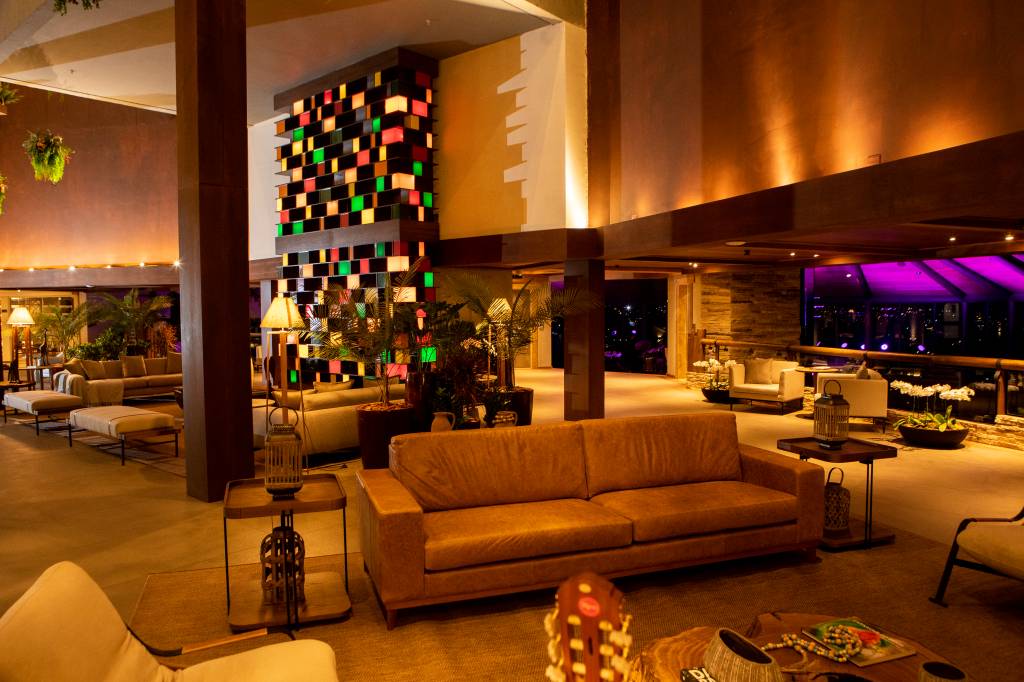 Bendito Cacao Resort & Spa (DIVULGAÇÃO) (8) Sofá aparece em primeiro plano em sala com luz indireta e parede estilizada em quadrados coloridos ao fundo.