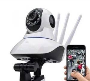Uma c&acirc;mera de vigil&acirc;ncia e um smartphone ao lado