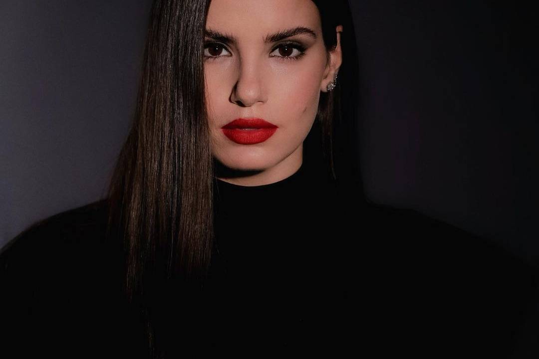 Imagem mostra Camila em foto, olhando com a cabela levemente inclinada para a câmera