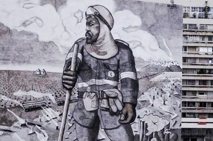 foto de mural que faz releitura de O Lavrador de Cagé, do Cândido Portinari. O mural, pintado em preto e branco, é gigante e está na lateral de um edifício no centro