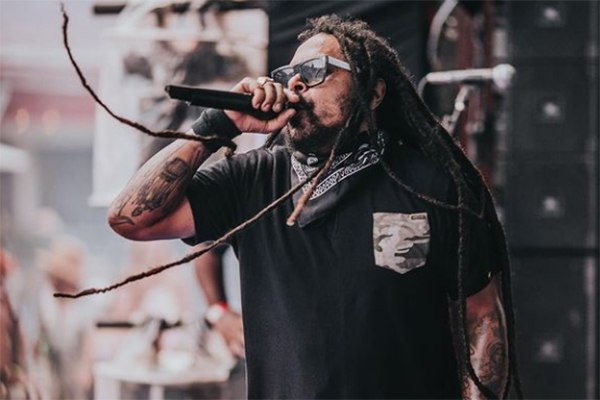 Imagem mostra Marcelo em palco, com óculos escuros, cantando