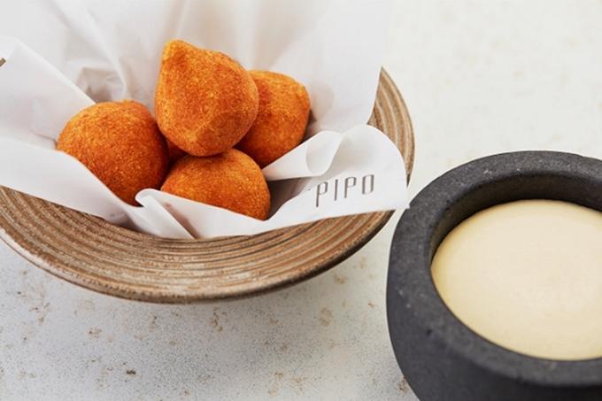 Porção de coxinha servida junto de molho de cor branca