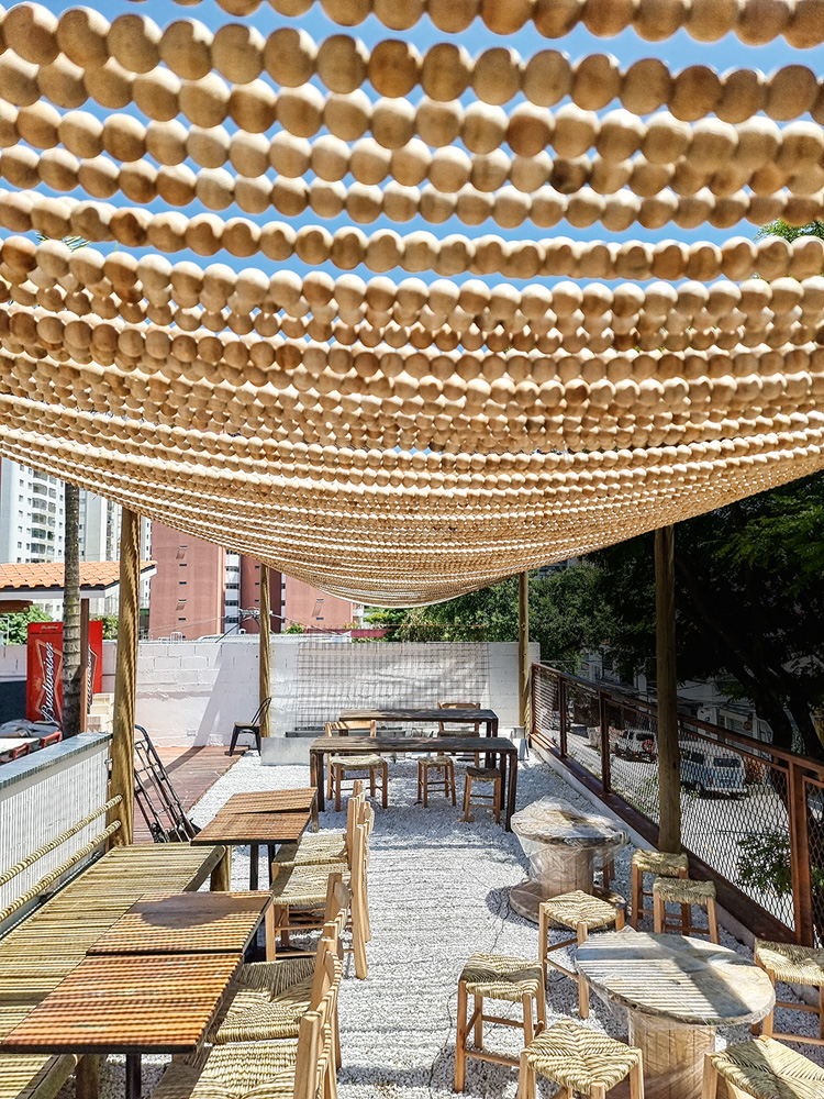 Jacaré Grill Terraço decorado com mesas e cadeiras de madeira