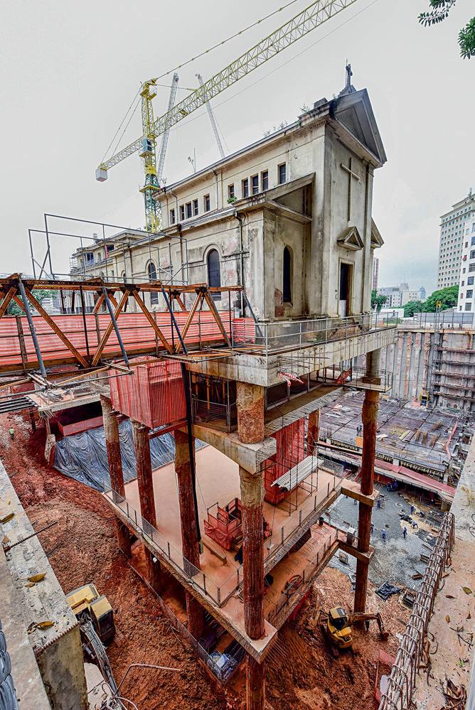 Capela Santa Luzia Foto mostra uma capela pendurada por diversas estruturas e ferros de construção