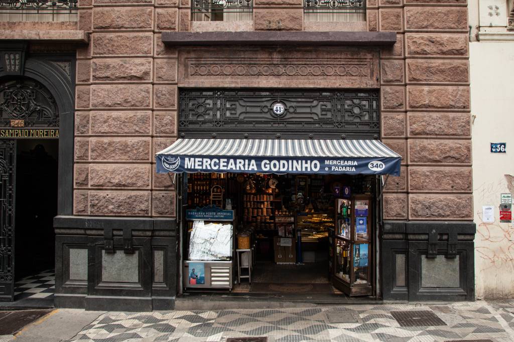 Achados ELO – Casa Godinho Fachada da Casa Godinho com porta em prédio.