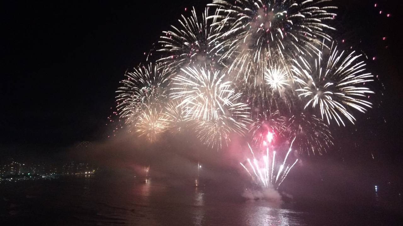 Queima de fogos de artifício durante a noite em uma praia