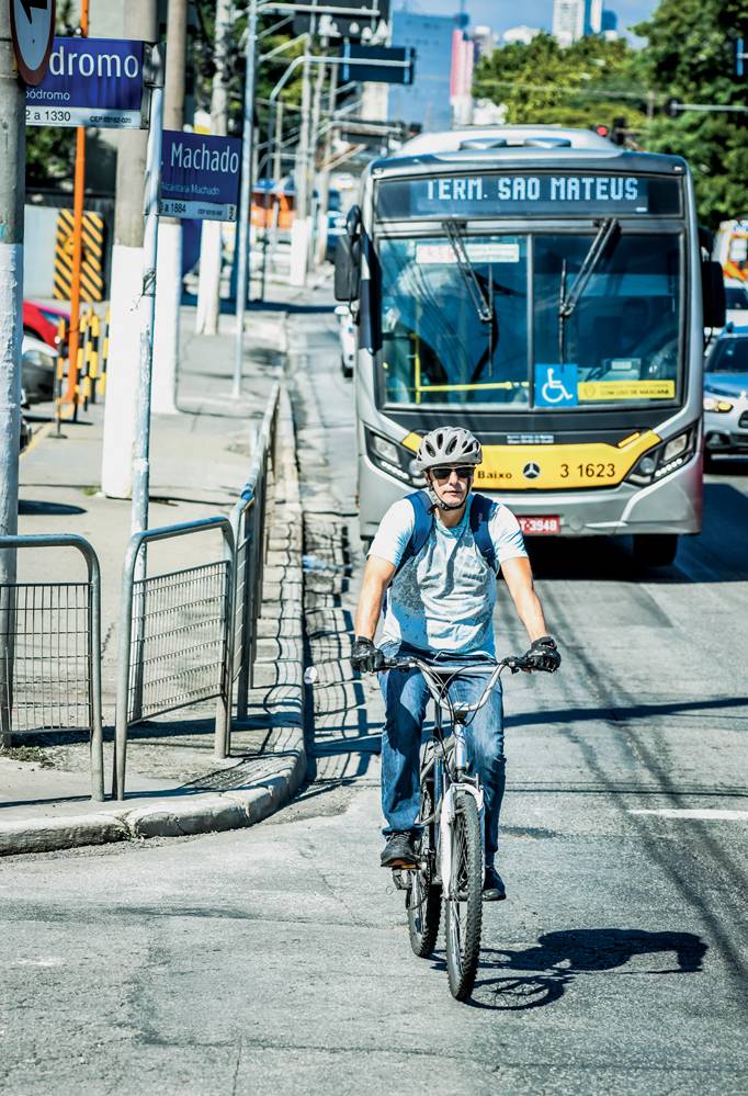 fernando corretor bicicletas são paulo Imagem mostra homem em bicicleta, de capacete e camiseta azul, na rua. Atrás dele, um ônibus amarelo.