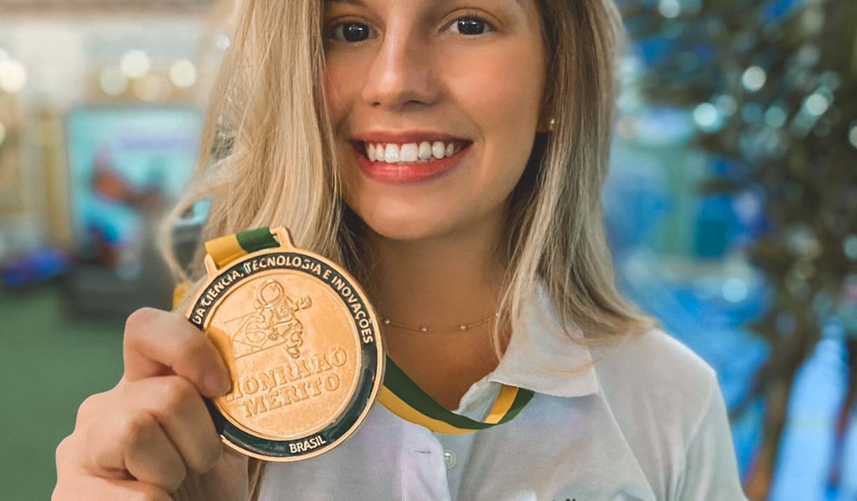 estudante Verena Paccola segura medalha de honra ao mérito
