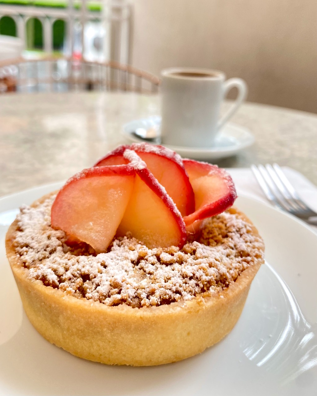 Cora Patisserie Tortinha de maçã servida em um prato raso de louça branca