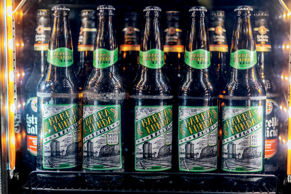 0K0A7262-2.jpg Garrafas de cerveja de rótulo verde enfileiradas.